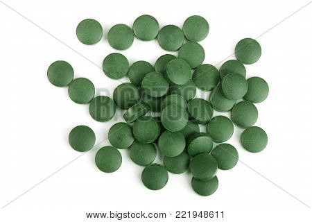 heap of Spirulina tablets algae nutritional supplement isolated on white background close up top view. Flat lay.