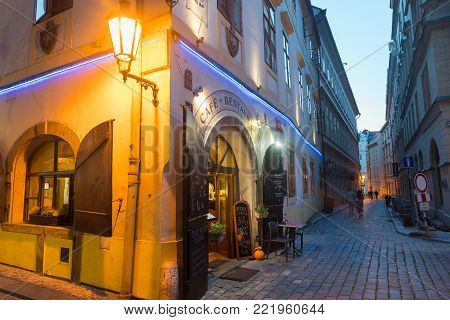 PRAGUE, CZECH REPUBLIC,- 29 AUGUST 29, 2017; Street corner under glow of lamp and entrance to restaurant with narrow lane