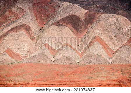 Interesting background of red banded strata viewed from Highway 163. The zigzag pattern is result of erosion of the tilted strata. Mexican Hat, Utah - USA