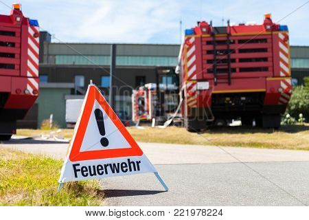 german Feuerwehr ( fire department ) sign stands near fire trucks