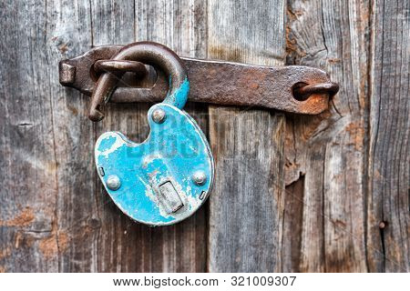 Blue Old Rusty Unlocked Padlock On A Wooden Door