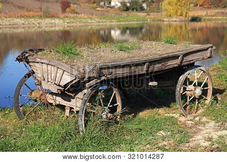 Old And Abandoned Wooden Traditional Cart (wain) In Far Ukrainian Village In Kiev Region. The Ancien