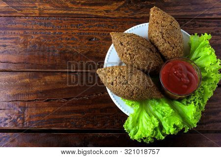 Fried Kibbeh With Tomato Sauce On A Plate, Over Rustic Wooden Table