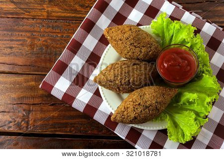 Fried Kibbeh With Tomato Sauce On A Plate, Over Rustic Wooden Table