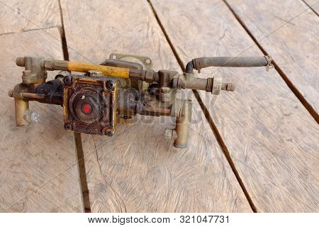 Old Pump Spare Parts On The Wood Background.