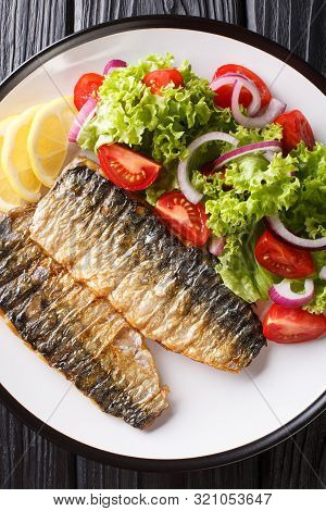Grilled Mackerel Fillet With Fresh Salad And Lemon Close-up On A Plate. Vertical Top View