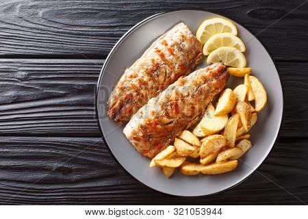 Grilled Fish Mackerel Fillet With A Side Dish Of Fried Potatoes Close-up On A Plate. Horizontal Top