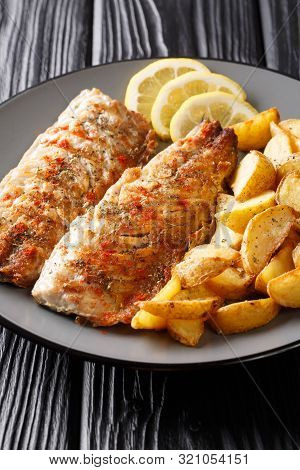 Spicy Tasty Grilled Mackerel Filet With Potato Wedges And Lemon Close-up On A Plate. Vertical
