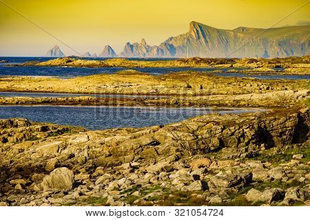 Seascape On Andoya Island. Scenic Rocky Coastline With Mountain Peaks In Distance, View From Bukkekj