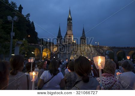 Lourdes, France, 24 June 2019: Evening Procession With Candles At The Shrine Of Lourdes In France