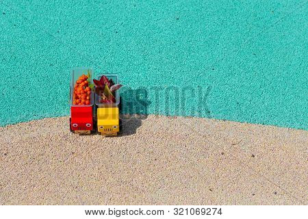 Two Toy Cars Trucks Brought Autumn With Them. In The Back Are Red Leaves And Rowan Berries. Copy Spa