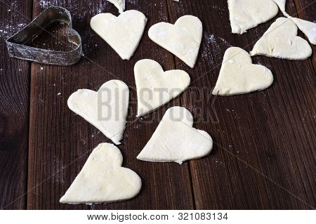 Making Heart Shaped Shortbread Cookies With Knives On A Brown Wooden Table.
