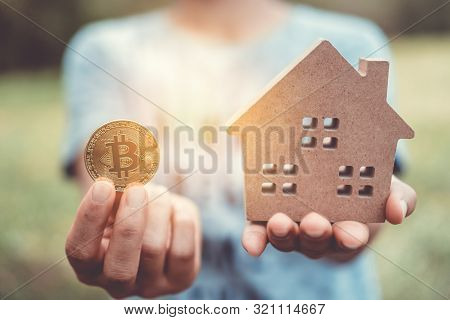 Copyspace Model Of A Little House And A Symbol Of Cryptocurrency That Woman Holds It Background. Dea