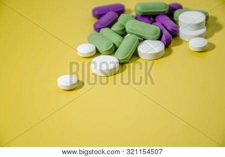 Multi-colored Pills On A Bright Yellow Background