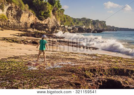 Boy Tourist On Pantai Tegal Wangi Beach, Bali Island, Indonesia. Bali Travel Concept. Traveling With