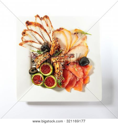 Fish platter with pink salmon, grilled eel, oil fish balyk and red caviar on elegant restaurant plate isolated on white background. Exquisite serving thin slices of salted and dried delicious seafood
