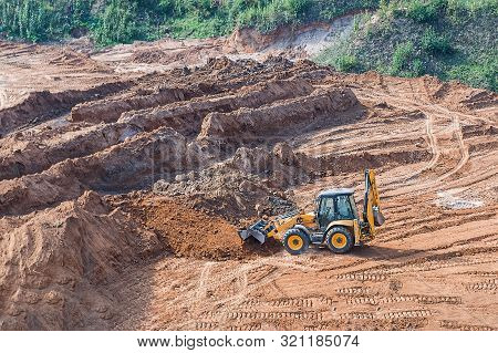 Wheel Loader Excavator Machine Working In Construction Site. Wheel Loader At Sandpit During Earthmov