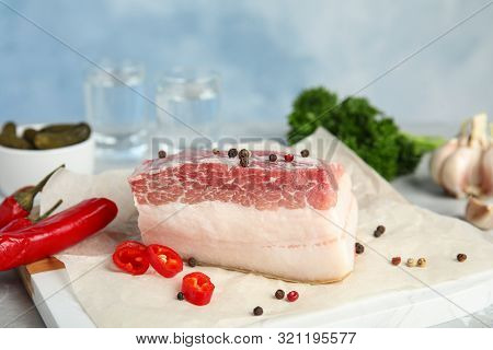 Composition With Pork Fatback And Spices On White Table Against Blue Background