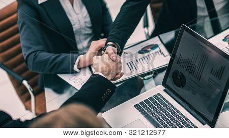 Handshake Of Business Partners On The Background Of The Financia
