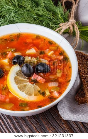 Traditional Russian Meat Soup Solyanka In Bowl On Rustic Wooden Table