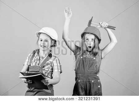 Little Kids In Helmet With Tablet And Hammer. Labor Day. 1 May. Small Girls Repairing Together In Wo
