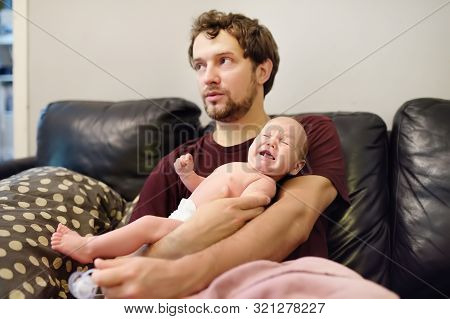 Confused Young Father Does Not Know How To Comforting A Crying Newborn Baby. Colic In The Baby. Diff