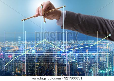 Businessman controlling the market with strings