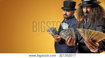 Two gentelmen holding dolars in their hands