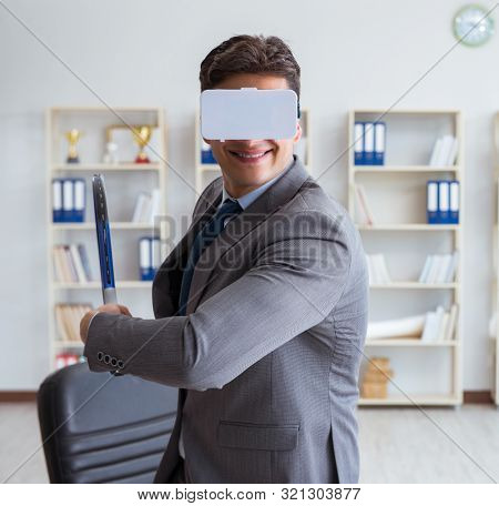 Businessman playing virtual reality tennis in office with VR gog