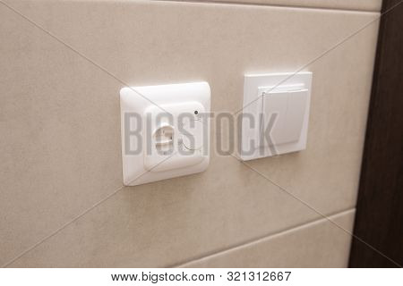 White Temperature Controller Of A Warm Floor On A Gray Wall.