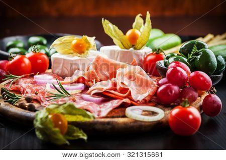 Large gourmet plater of party snacks presented on wooden board