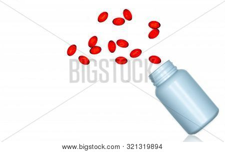Pour Red Soft Gel Capsule Pills Out Of Drug Bottle Isolated On White Background. Red Soft Gelatin Ca