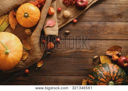 Autumn Frame Made Of Pumpkins, Dried Fall Leaves, Apples, Red Berries, Walnuts, Blanket On Wooden Ta