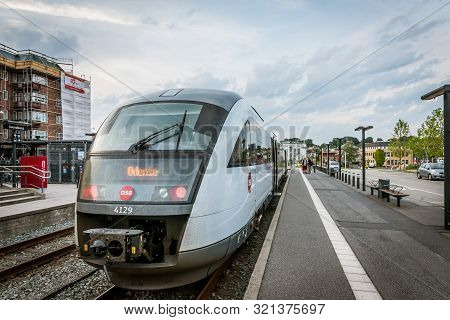 Passengers At The Platform In Front Of A Train To Odense At The Railway- Station In Svenborg, Denmar