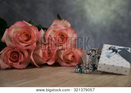 Dolce Vita Roses With Dotted White Present Box On Wood Background