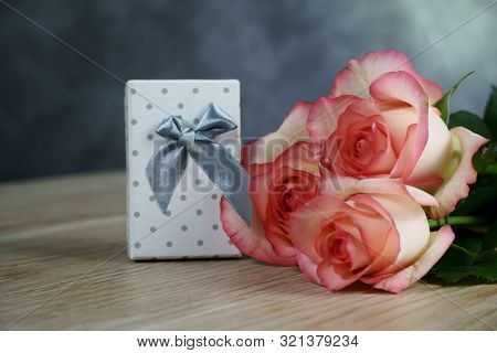 Dolce Vita Roses With Dotted White Present Box On Wood Background