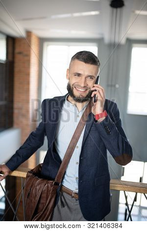 Smiling Businessman Speaking With Colleague By The Phone