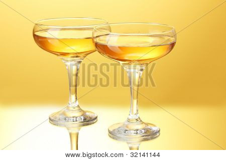 glas champagne på gul baggrund