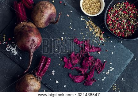 Healthy Homemade Vegetable Chips From Beetroot With Salt, Pepper And Origano On Black Background. Or