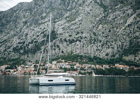 Beautiful View Of The Mountains, Coastal City, Sea And A Sailboat Or Boat In The Foreground. Natural