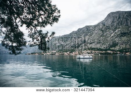 Beautiful View Of The Mountains, Coastal City, Sea And A Sailboat Or Boat In The Foreground. Natural