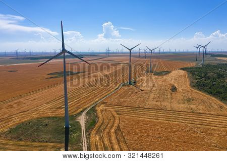 Eolian Field And Wind Turbines Farm On Countryside In A Sunny Day