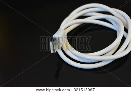 White Long Wire For Computer And Office Equipment, Usb Cable Microusb Connector On A Black Glossy Su