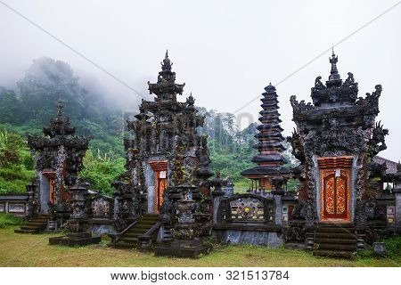 Foggy Morning Scenic View Of Ancient Balinese Hindu Temple At Buyan Lake In Mountain Rainforest Near