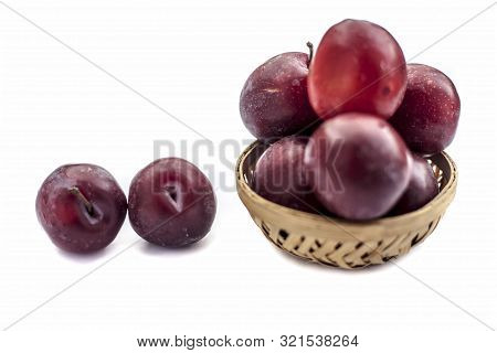 Raw Organic Red Ripe Plums In A Brown-colored Basket Isolated On White For Easy To Use For Any Purpo