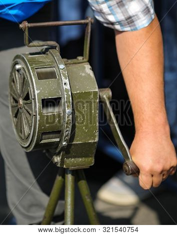Shallow Depth Of Field Image With A Man Handling A Vintage Hand Crank Air Raid Siren