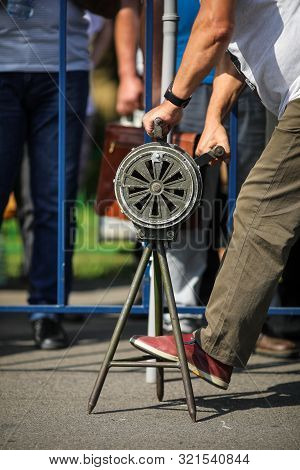 Shallow Depth Of Field Image With A Man Handling A Vintage Hand Crank Air Raid Siren