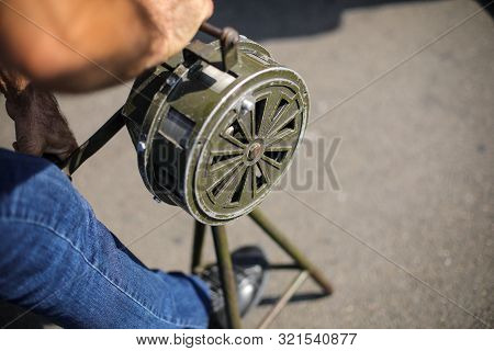 Shallow Depth Of Field Image With A Man Handling A Vintage Hand Crank Air Raid Siren