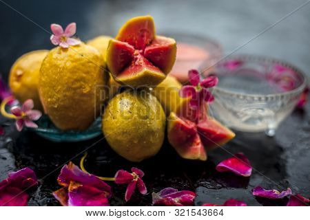 Guava Pulp And Water Well Mixed In A Glass Bowl On The Wooden Surface Along With Some Raw Cut Guava,