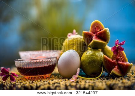 Guava Face Mask For Dry Skin On A Wooden Surface With Vivid Colors I.e., Guava Pulp, Egg Yolk, Oatme